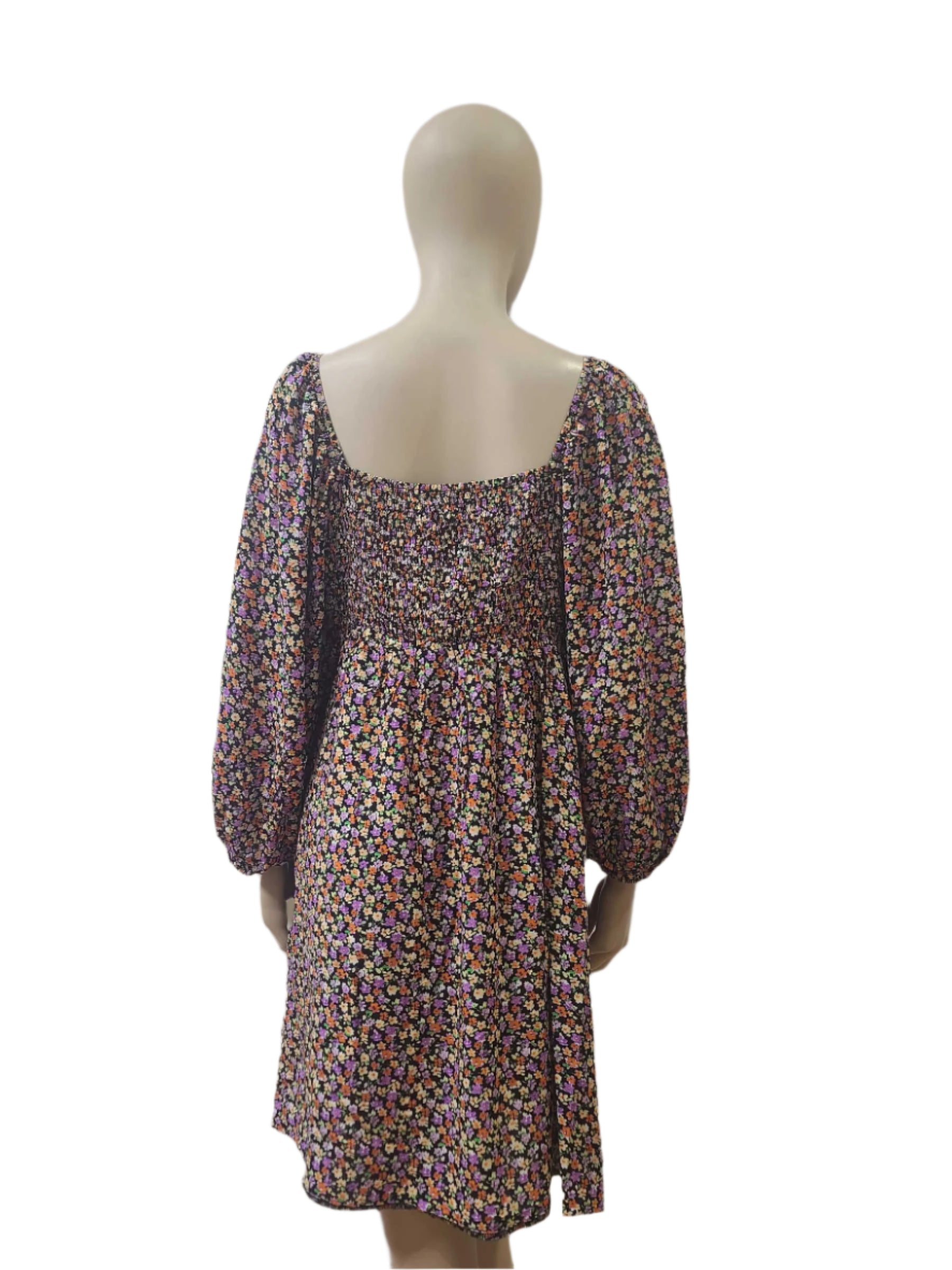 Back view of floral mini dress with shirred elastic panel