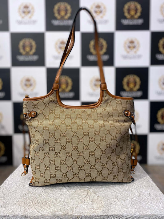 Front view of FOXER beige monogram hand bag with dual handles and tan leather accents